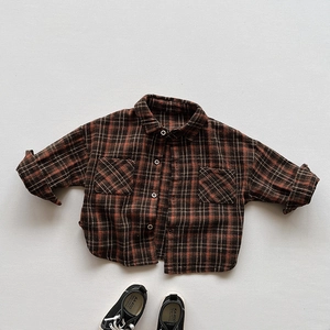Detail of children's long-sleeve plaid shirt featuring classic brown and black check pattern