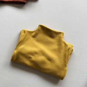 Close-up of ginger yellow high neck kids top with soft brushed thermal fabric texture