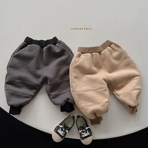 Detail view of kids' fleece-lined joggers in dark grey and khaki with ribbed cuffs