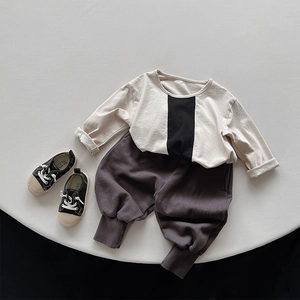 Flat lay of kids autumn cotton set with beige long sleeve T-shirt and charcoal sweatpants