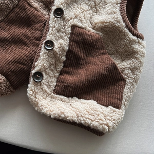 Dettaglio del gilet caldo per bambini con tasca in velluto e soffice pelliccia beige