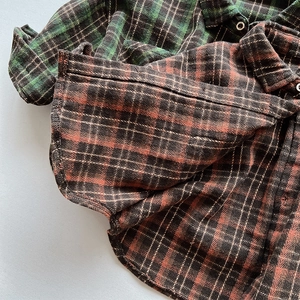 Detailed close-up of flannel plaid shirts showing soft brushed fabric and metal buttons