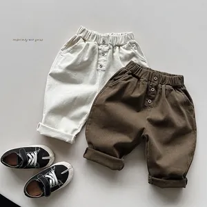 Flat lay of kids fleece casual pants in beige and coffee with wood buttons