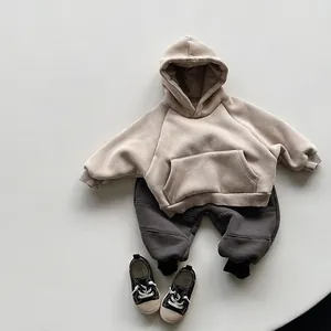 Flat lay of soft beige fleece hoodie with kangaroo pocket and grey joggers for kids