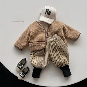 Flat lay of kids winter outfit with beige fleece cardigan and striped lantern pants