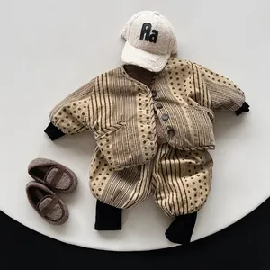 Flat lay of khaki and brown polka dot baby clothing set with hat and plush shoes