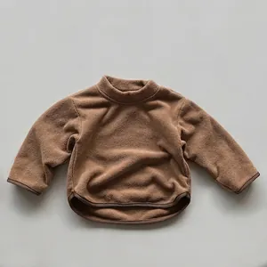 Detail view of caramel brown fleece kids sweatshirt with soft texture and side slits