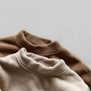 Detailed texture of soft fleece fabric on brown and cream warm thermal mock neck tops