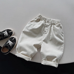 Detail of kids cream fleece trousers featuring elastic waist and side pockets with rolled cuffs