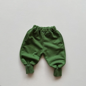 Detailed view of dark green kids joggers showing elastic waistband and ribbed cuffs