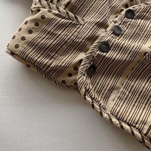 Close-up of winter thick corduroy jacket with retro buttons and striped dot pattern