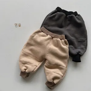 Detailed flat lay of children's fleece joggers in dark grey and beige with ribbed cuffs