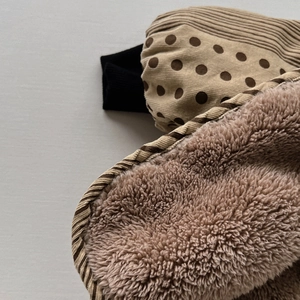 Detail of warm corduroy polka dot fabric with thick sherpa fleece lining and ribbed cuff