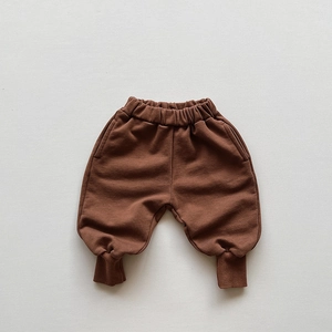 Close-up of kids brown cotton sweatpants with elastic waist and ribbed cuffs for autumn