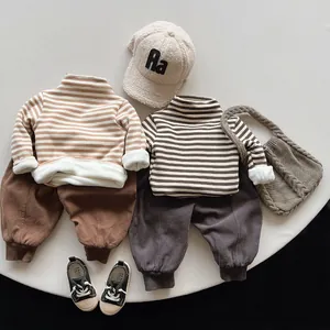 Flat lay of toddler winter outfit sets featuring striped fleece tops and harem pants