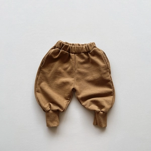 Flat lay of brown cotton children's sweatpants with elastic waist and ribbed cuffs