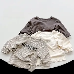 Détail à plat de t-shirts enfants en coton à manches longues avec imprimé MOMENT
