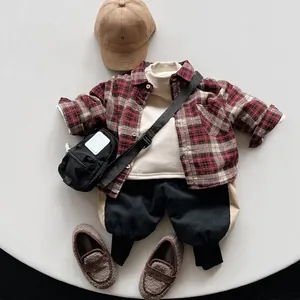 Flat lay of vintage plaid fleece-lined children's shirt with pants and accessories