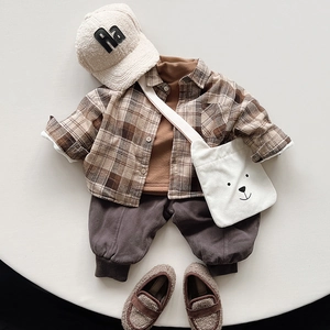 Flat lay of kids vintage winter outfit with plaid shirt and warm gray fleece pants