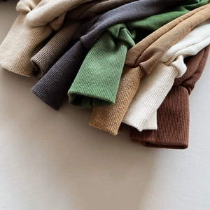 Close-up of ribbed cuffs on children's multi-color casual knit jogger pants in earth tones