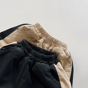Detail of elastic waistband and side pockets on thick cotton trousers for children