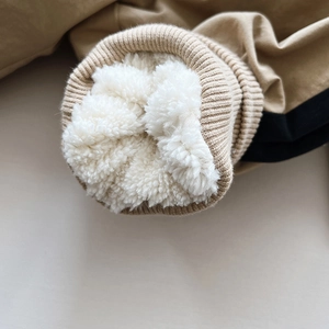 Close-up of kids winter trousers showing thick white fleece lining and ribbed cuffs