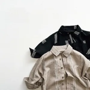 Détail de chemises enfant à manches longues en coton avec texture rayée et col classique
