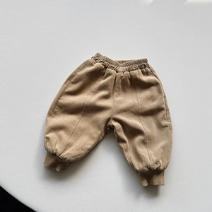 Detailed macro view of khaki fleece-lined corduroy pants with elastic waist and ribbed cuffs