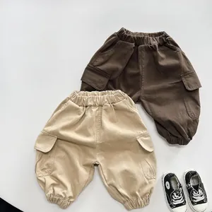 Detailed flat lay of children cargo pants in beige and brown cotton twill fabric