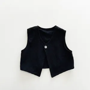 Detail of minimalist black kids V-neck vest with single button and premium fabric texture
