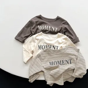Detail von geripptem Ausschnitt und MOMENT-Buchstabendruck auf Baumwoll-Kindershirts