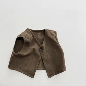 Close-up of deep brown cotton vest for kids with textured fabric and single button detail