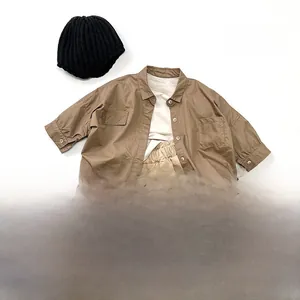 Mise à plat d'une chemise vintage marron pour enfant et d'un pantalon cargo beige à poches