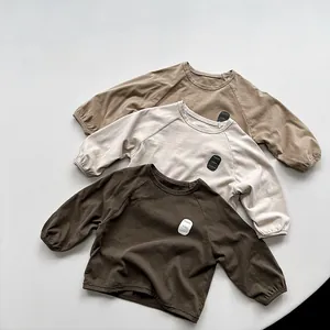 Detail of raglan sleeves and letter badge on cotton long-sleeve kids' sweatshirts
