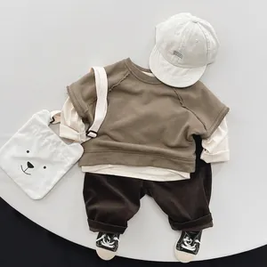 Flat lay of a children olive green sweatshirt and brown corduroy pants outfit set