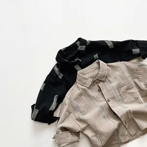 Détail de chemises en coton à manches longues avec texture verticale et boutons bois