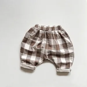 Détail de la taille élastique du pantalon sarouel à carreaux marron pour enfant