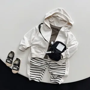 Kinder Freizeitoutfit mit Kapuzenjacke, gestreifter Hose und kleiner Umhängetasche