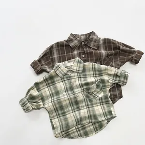 Flat lay of retro plaid cotton shirts for kids in brown and green flannel fabric