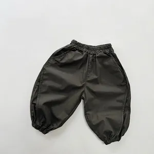 Flat lay of olive green cotton kids joggers featuring elastic waist and ribbed cuffs