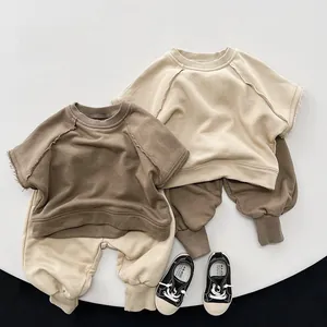Flat lay of soft cotton kids' sportswear sets in brown and cream colors with canvas shoes