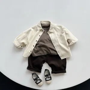 Flat lay of beige cotton shirt, brown t-shirt and corduroy shorts for kids
