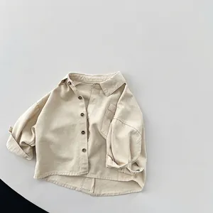 Détails d'une chemise beige vintage pour enfants avec col à revers et boutons simples