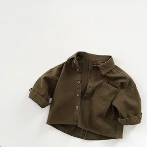 Détail de chemise enfant vert olive en coton avec boutons et poche de poitrine