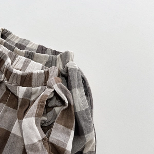Détail de pantalon enfant à carreaux montrant la taille élastique et le tissu vichy