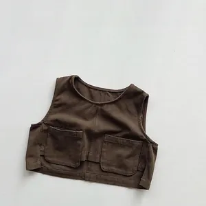 Detailed view of dark brown canvas kids utility vest featuring two large front pockets
