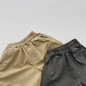 Detail of elastic waistband and side pockets on cotton kids casual trousers