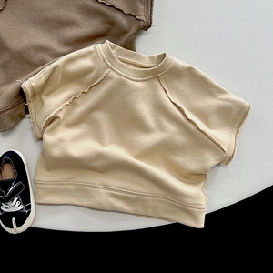 Close-up of cotton kids sweatshirt with raw edge stitching and ribbed crew neck design