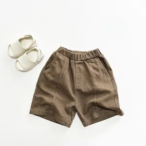 Vista detallada del pantalón corto marrón para niños con cintura elástica y costura frontal