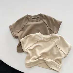 Detail of raw edge stitch on brown and beige cotton vests for kids in Korean style